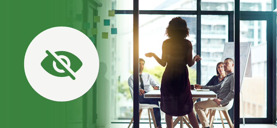 A woman stands and addresses a group in a glass-walled conference room, delivering a presentation. The left side of the image features a green overlay with a white circle and an icon of an eye crossed out—symbolizing invisibility or unconscious bias in leadership or communication dynamics.